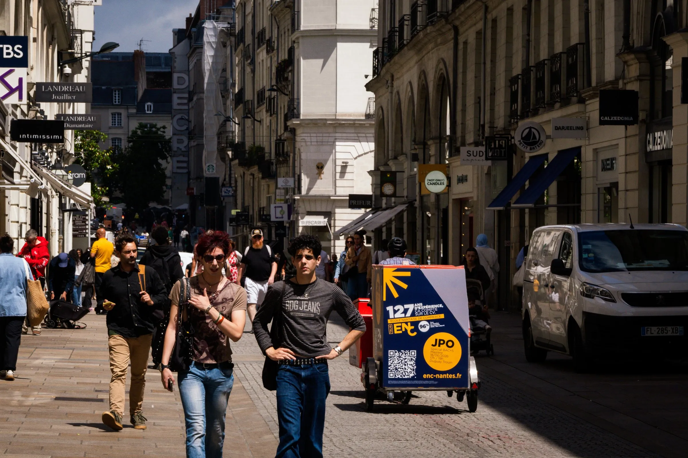 Vélo publicitaire LCDG dans une rue piétonne animée