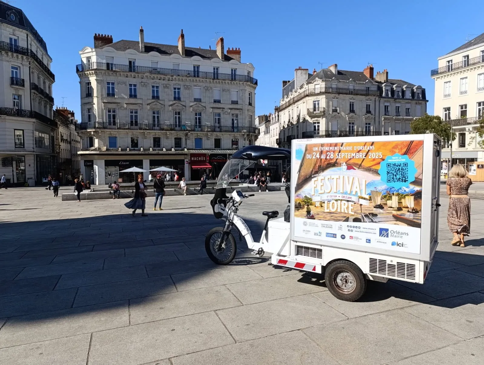 Triporteur publicitaire LCDG en campagne sur une grande place de centre-ville