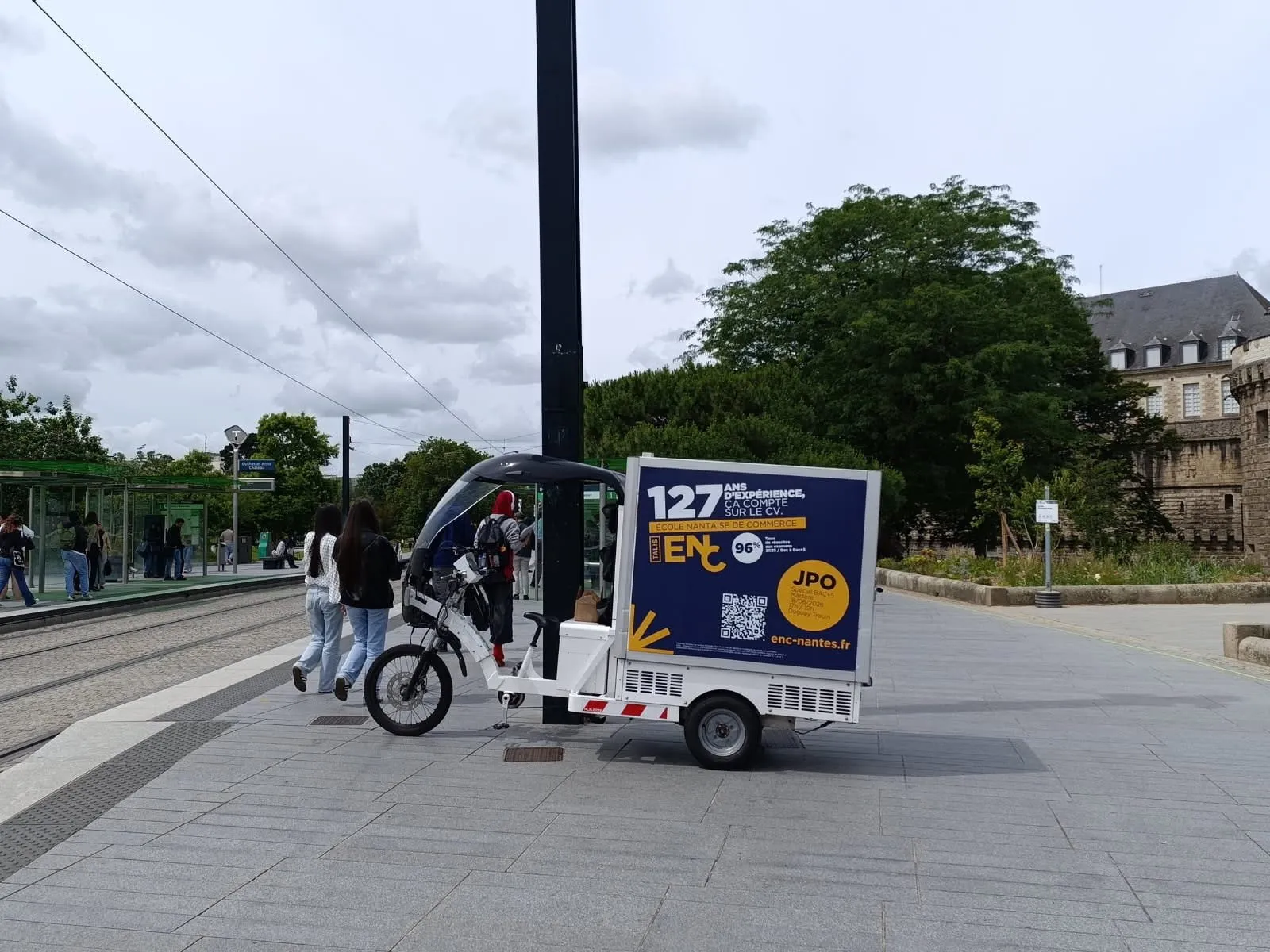 Vélo publicitaire LCDG sur un parvis très fréquenté