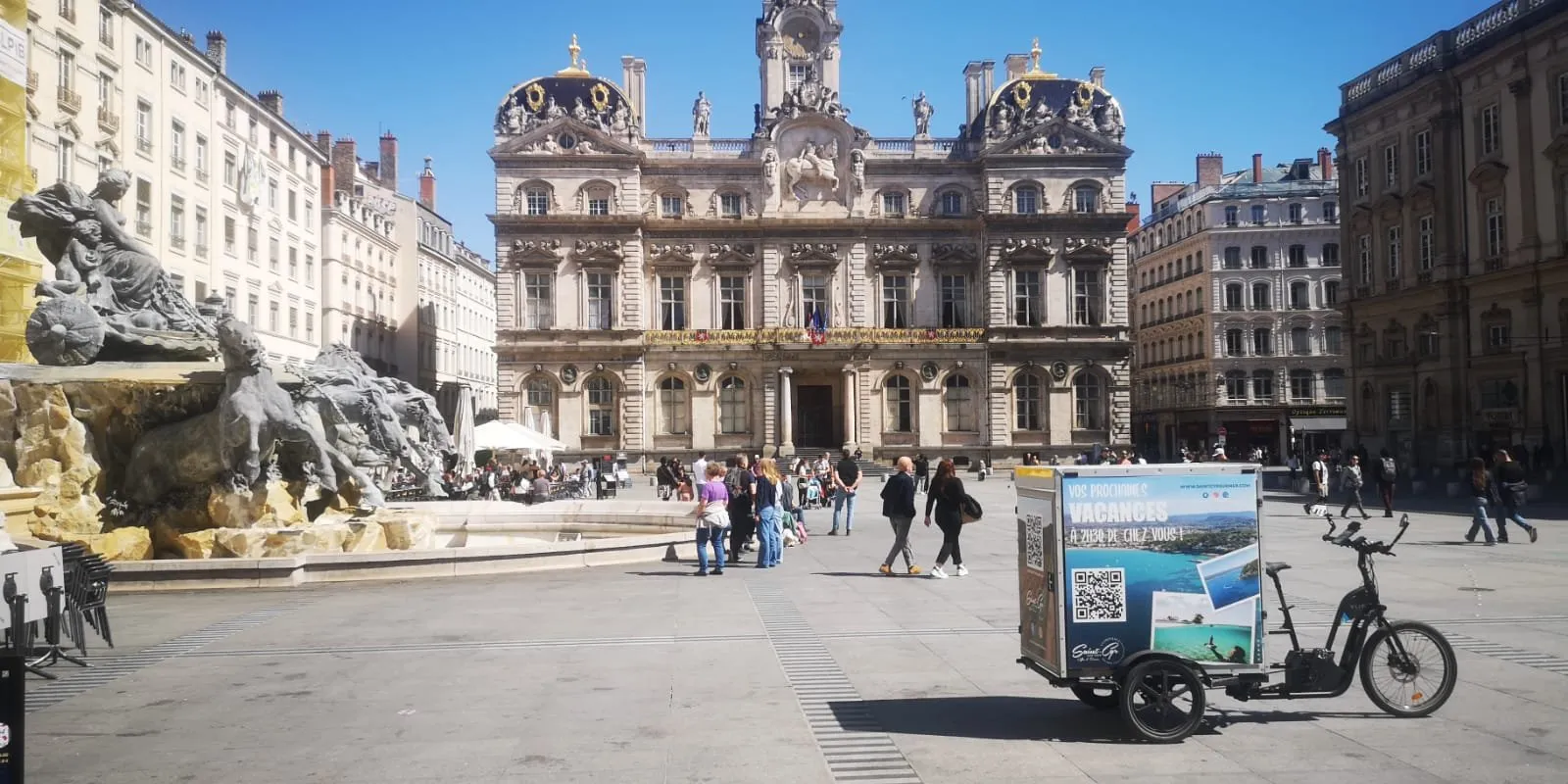 Vélo publicitaire LCDG en campagne sur une place très fréquentée