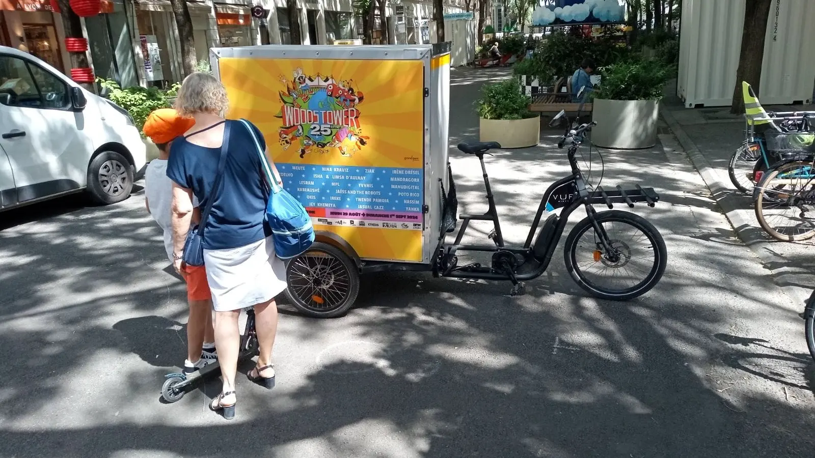 Lee vélo publicitaire Woodstower dans la ville de Lyon captant l'attention de deux passants.